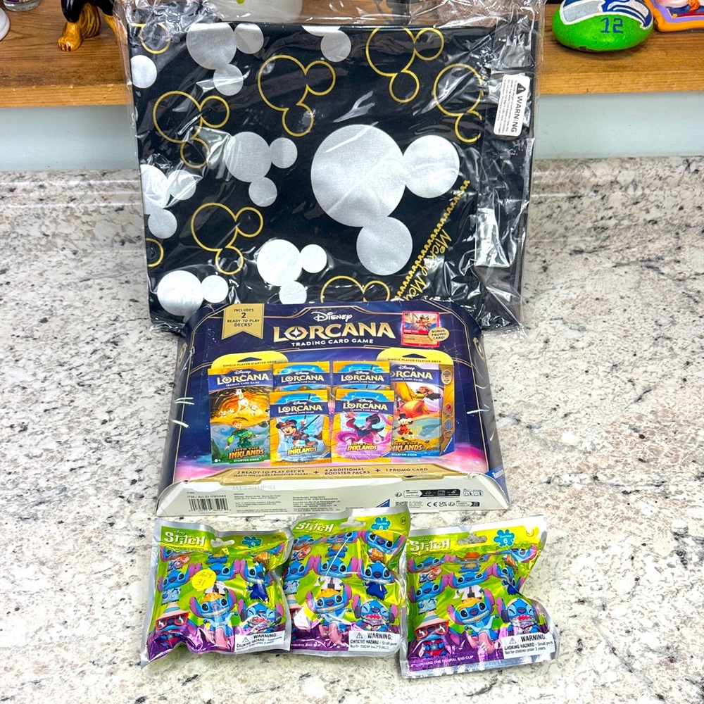 Disney Lorcana Gift Set with Black and Gold Tote and stitch figural bag clips.